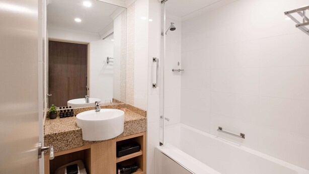 A modern bathroom with two sinks, a shower, and a glass-enclosed shower area. - Terrace Hotel Adelaide (Adelaide)