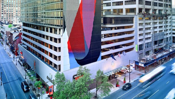A modern building with a unique facade, surrounded by other high-rise buildings.