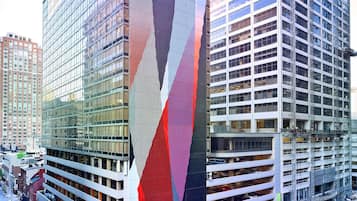 Un edificio moderno con una fachada singular, rodeado de otros rascacielos.