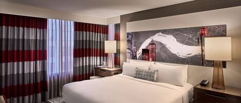 A hotel room with a large bed, two bedside tables, a nightstand, a desk, and a chair.
