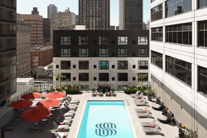 A rooftop pool area with lounge chairs and umbrellas, surrounded by modern buildings. - Sonesta Philadelphia Rittenhouse Square (Philadelphia)