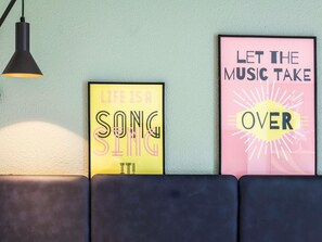 Two framed motivational posters on a wall, a black pendant light, and a dark-colored sofa. - Ibis Paris Bastille Faubourg Saint Antoine 11ème (Paris)