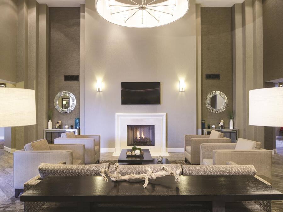 A spacious lobby with a fireplace, seating area, and decorative mirrors.