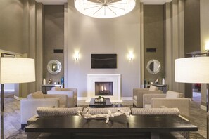 A spacious lobby with a fireplace, seating area, and decorative mirrors.