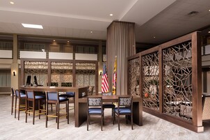 A conference room with a long table, multiple chairs, and a flag display.