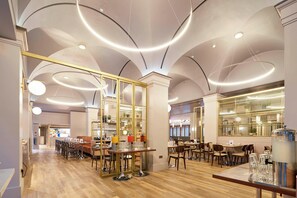 Un comedor moderno con una mesa larga, sillas y una zona de bar con taburetes.