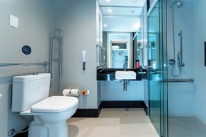 Ein modernes Badezimmer mit Toilette, Waschbecken und einer Duschkabine.