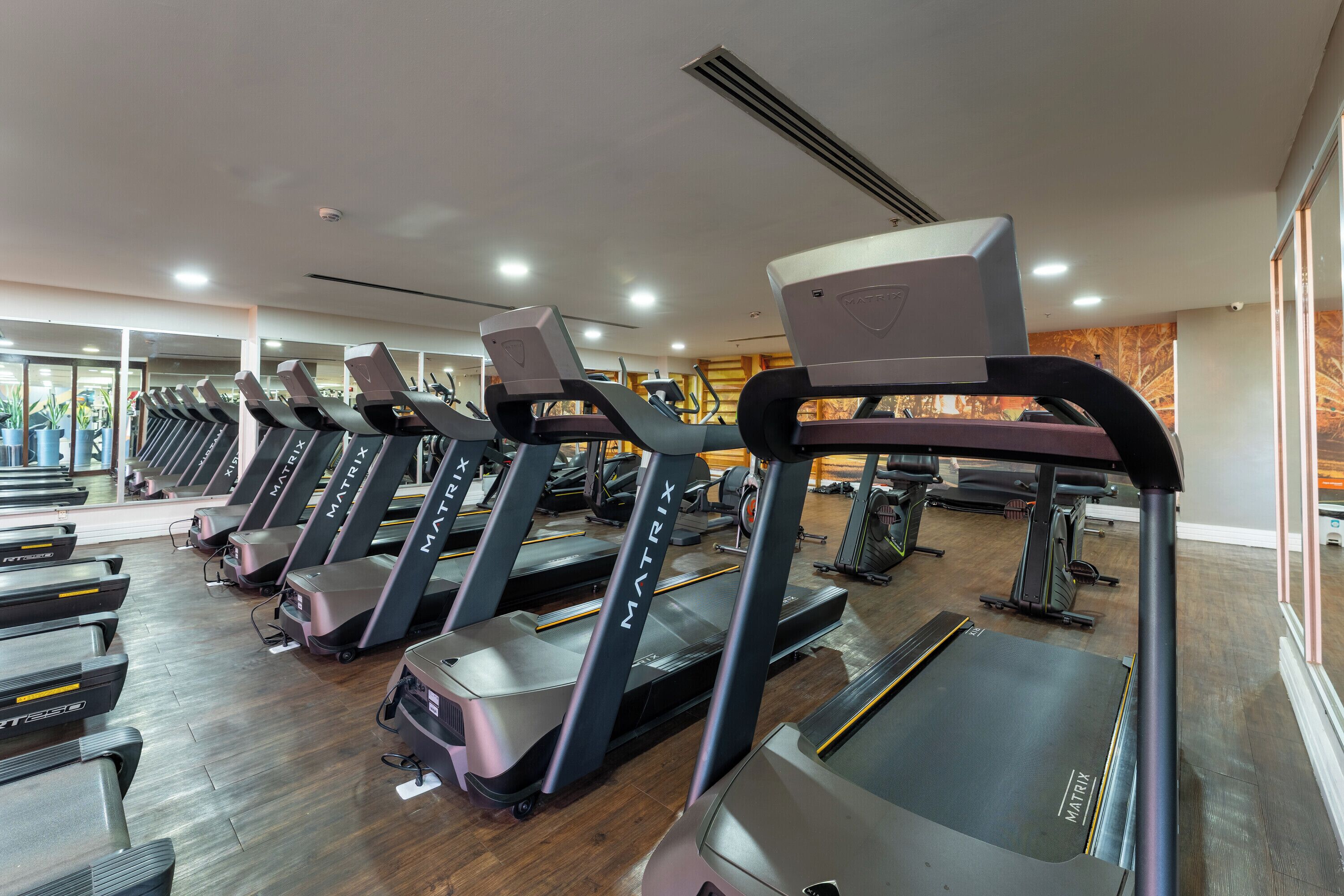 A gym with multiple treadmills, exercise bikes, and weight machines.