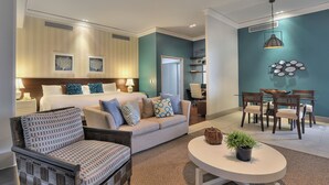 A modern hotel room with a bed, sofa, dining table, chairs, and a small potted plant. - Hotel Deville Prime Salvador (Salvador)