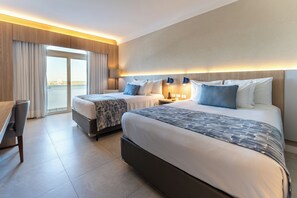 Une chambre d’hôtel avec deux lits, un bureau et une vue sur la ville.