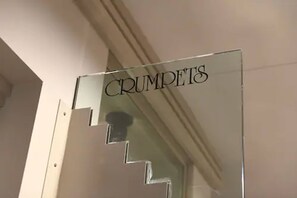 A staircase with a sign that reads "CRUMPETS."