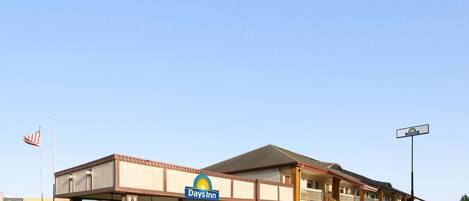 A Days Inn with a two-story structure, a covered entrance, and a flagpole with an American flag.