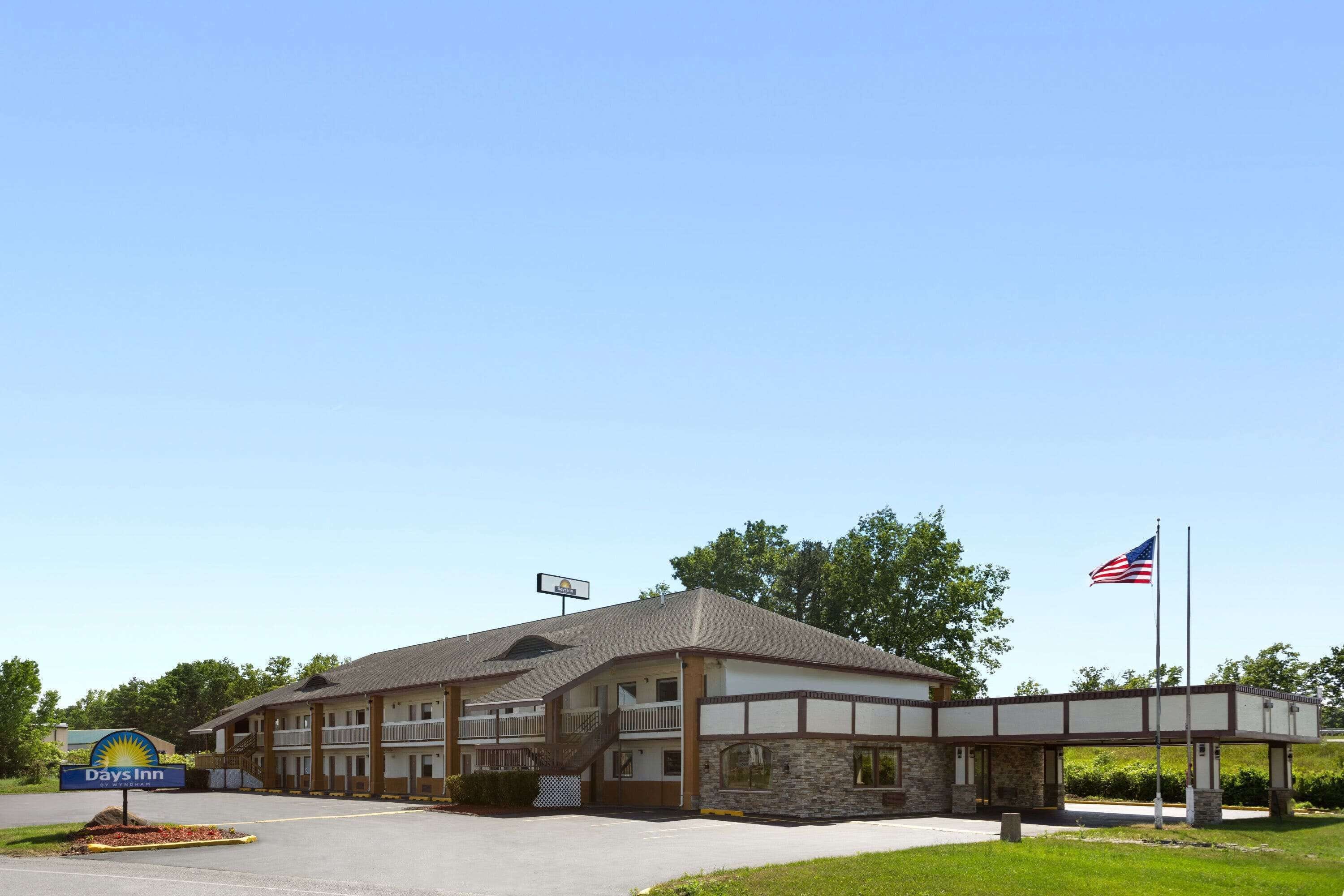 A Days Inn with a two-story building, a covered walkway, and an American flag.