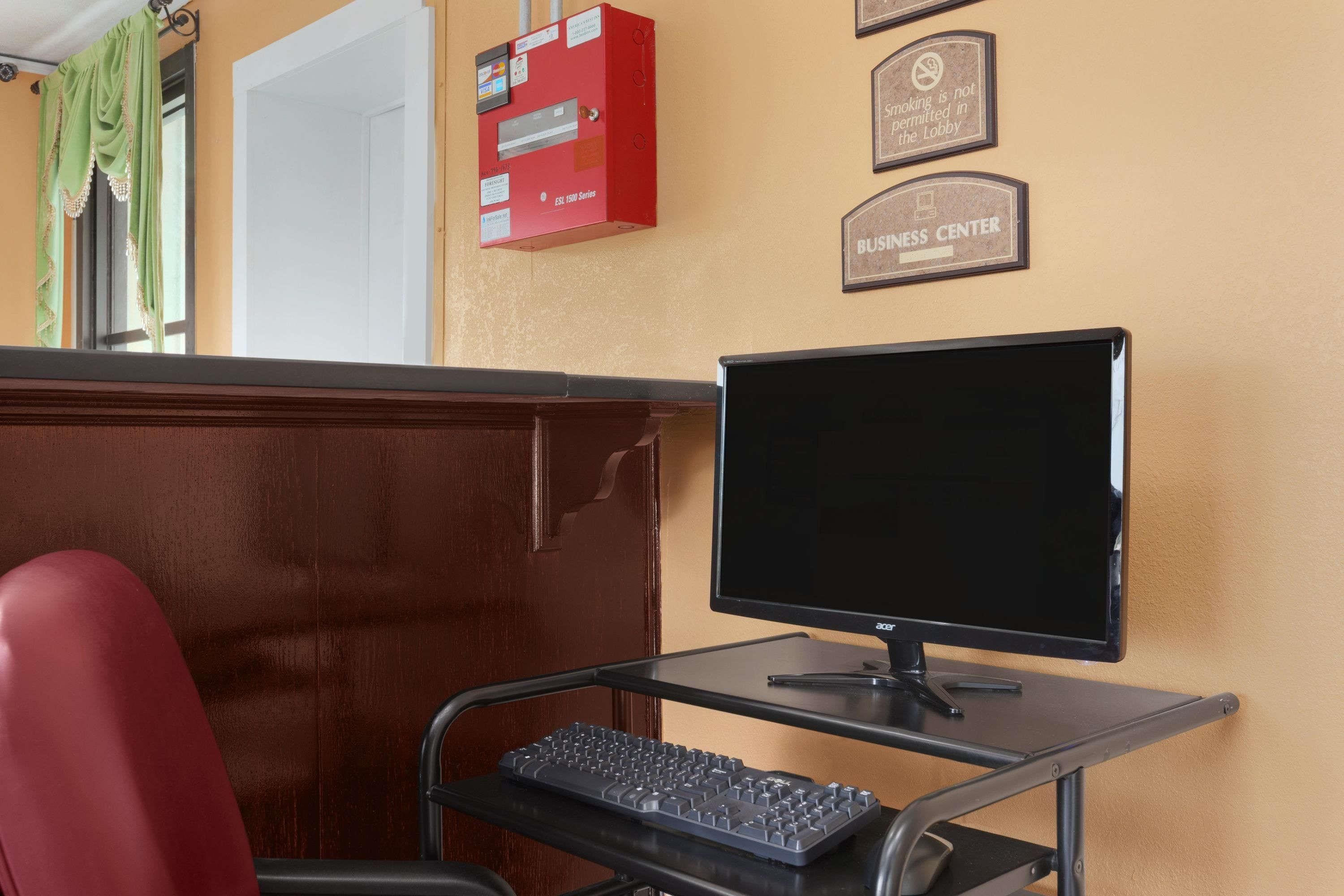 Un espace d’accueil comprenant un comptoir, un ordinateur, un clavier et une boîte rouge contenant le dispositif d’alarme incendie.