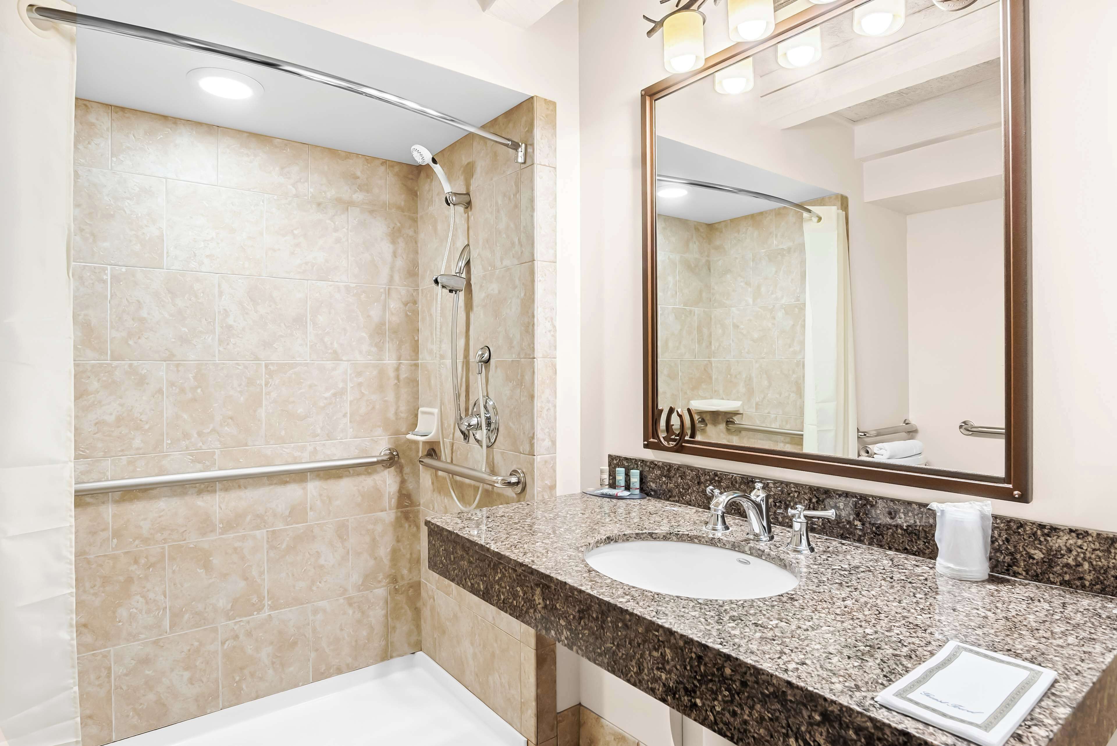 Une salle de bain moderne avec une douche, un lavabo et un grand miroir.