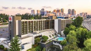 A modern hotel with a rooftop pool and a view of the city skyline. - Hilton Bellevue (Bellevue)