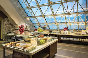 A breakfast buffet with various food items and a glass enclosure.