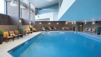 Relax by the rectangular pool surrounded by lounge chairs and lush greenery.