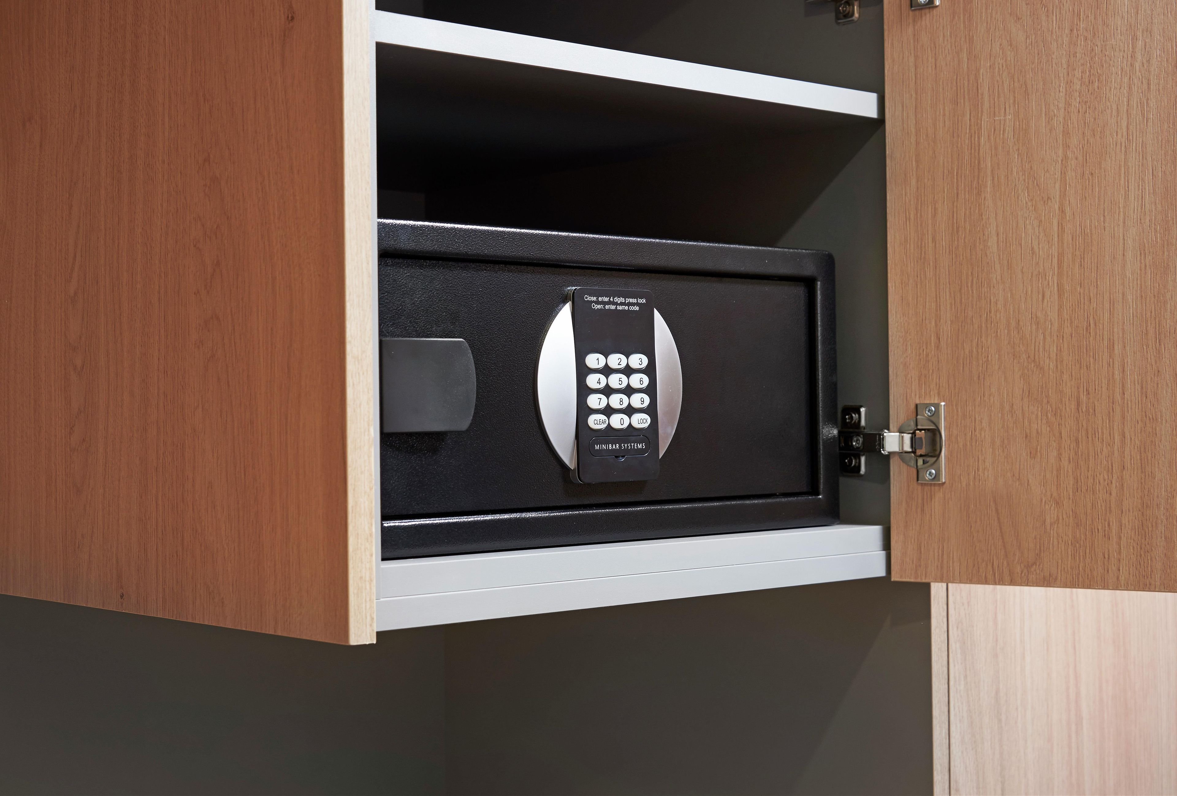 A wooden cabinet with a built-in safe containing a keypad lock.