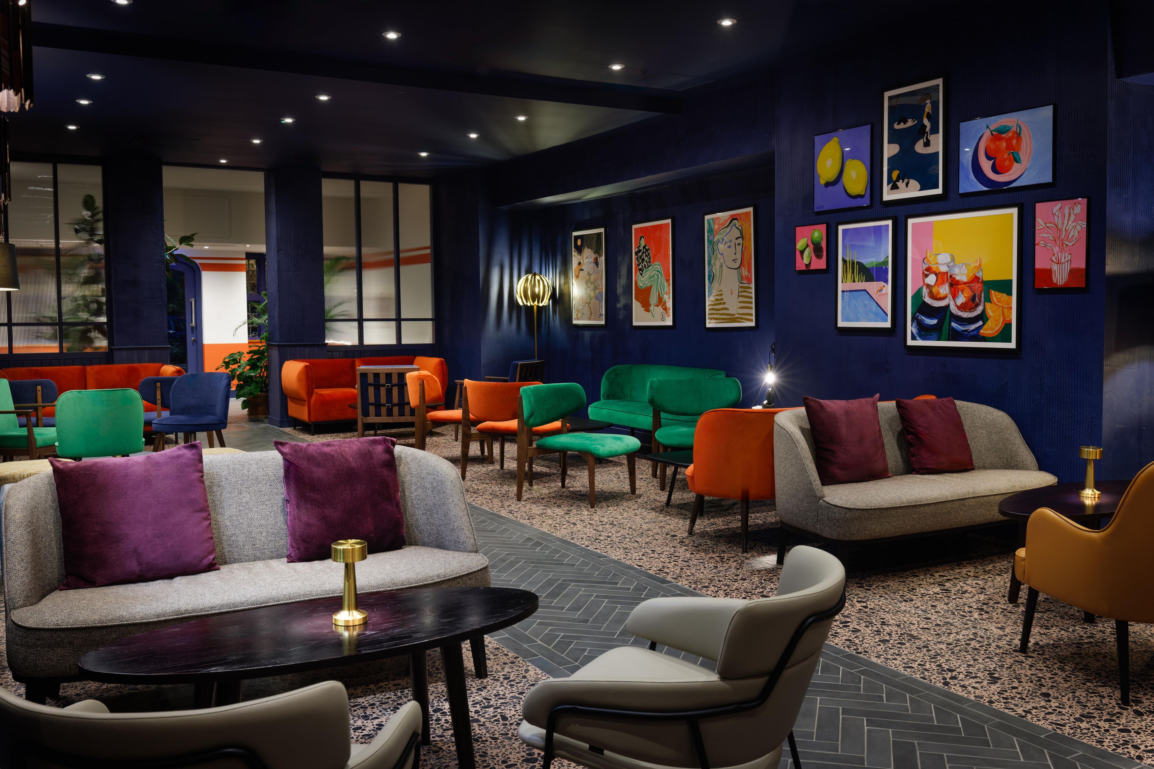 A modern lounge area with sofas, chairs, and artwork on the walls.