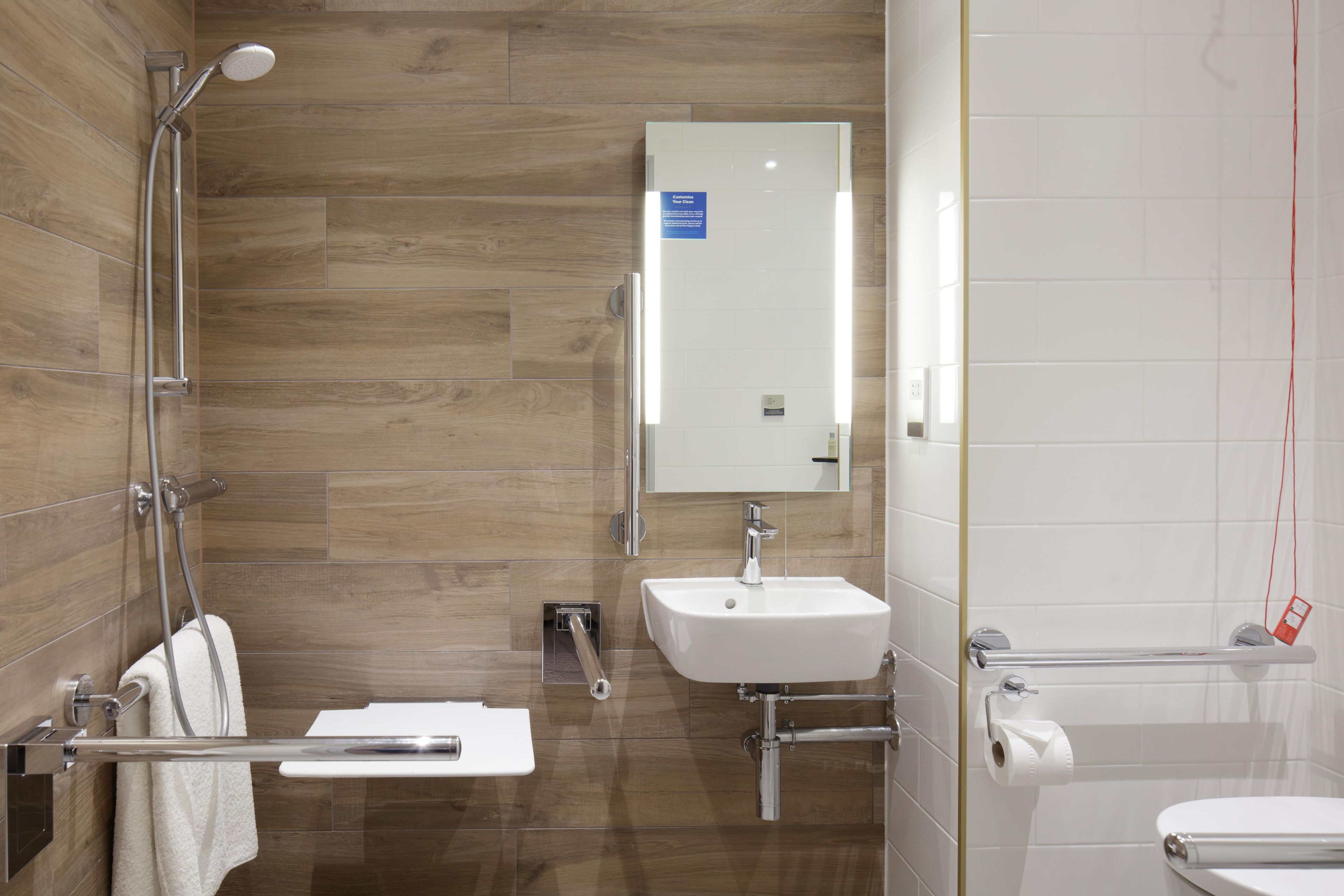 A modern bathroom with a shower, sink, and toilet.