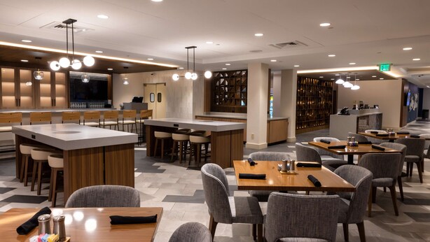 A modern restaurant with a bar area, multiple seating options, and a visible exit sign. - DoubleTree by Hilton Tinton Falls - Eatontown (Tinton Falls)
