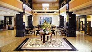 A spacious lobby with a central seating area, high ceilings, and a chandelier. - Hotel New Otani Chang Fu Gong (Beijing)