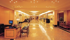 A hotel lobby with a reception desk, seating area, and a staircase. - Hotel New Otani Chang Fu Gong (Beijing)