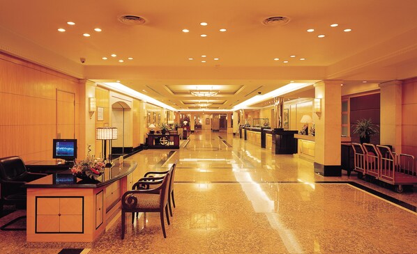 A hotel lobby with a reception desk, seating area, and a staircase. - Hotel New Otani Chang Fu Gong (Beijing)