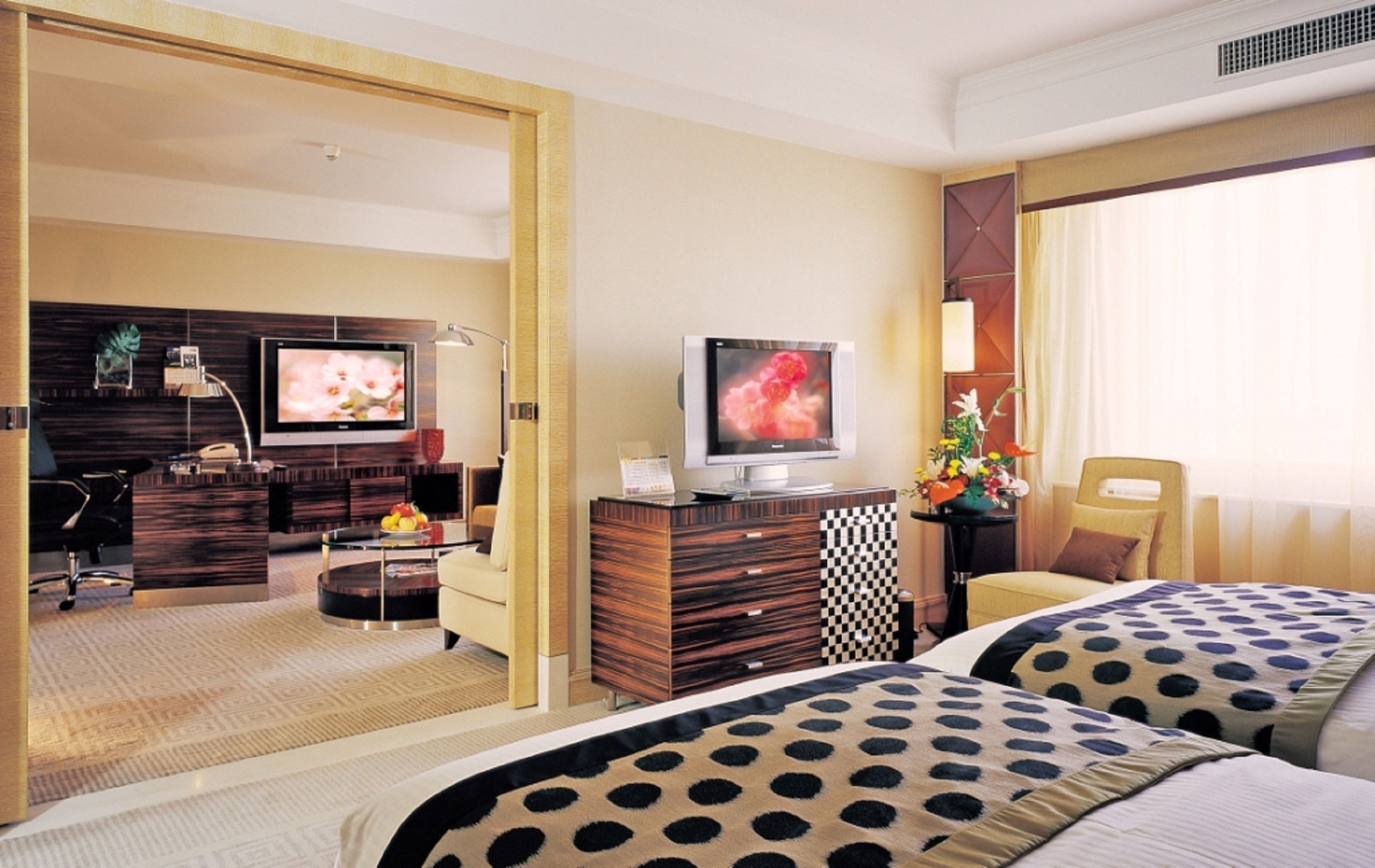 Habitación de hotel con dos camas, televisión, escritorio y una silla.