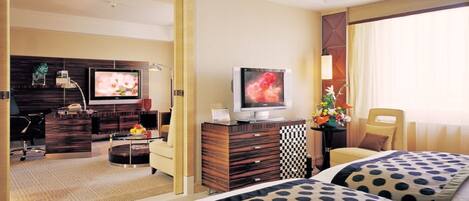 Habitación de hotel con dos camas, televisión, escritorio y una silla.