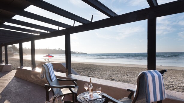 A beachside seating area with a table set for two, overlooking the ocean. - La Jolla Beach and Tennis Club (La Jolla)