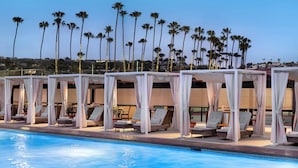 A poolside area with sun loungers and white canopies, palm trees in the background, and a clear sky. - La Jolla Beach and Tennis Club (La Jolla)