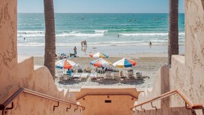 A staircase leading to a beach with umbrellas and people in the water. - La Jolla Beach and Tennis Club (La Jolla)