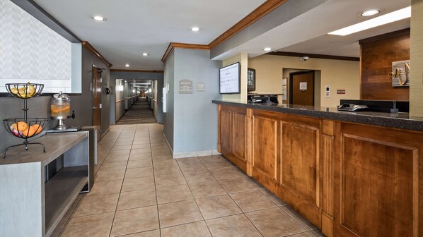 A hotel lobby with a long hallway, a reception desk, and a fruit bowl. - Best Western Plus North Canton Inn & Suites (North Canton)