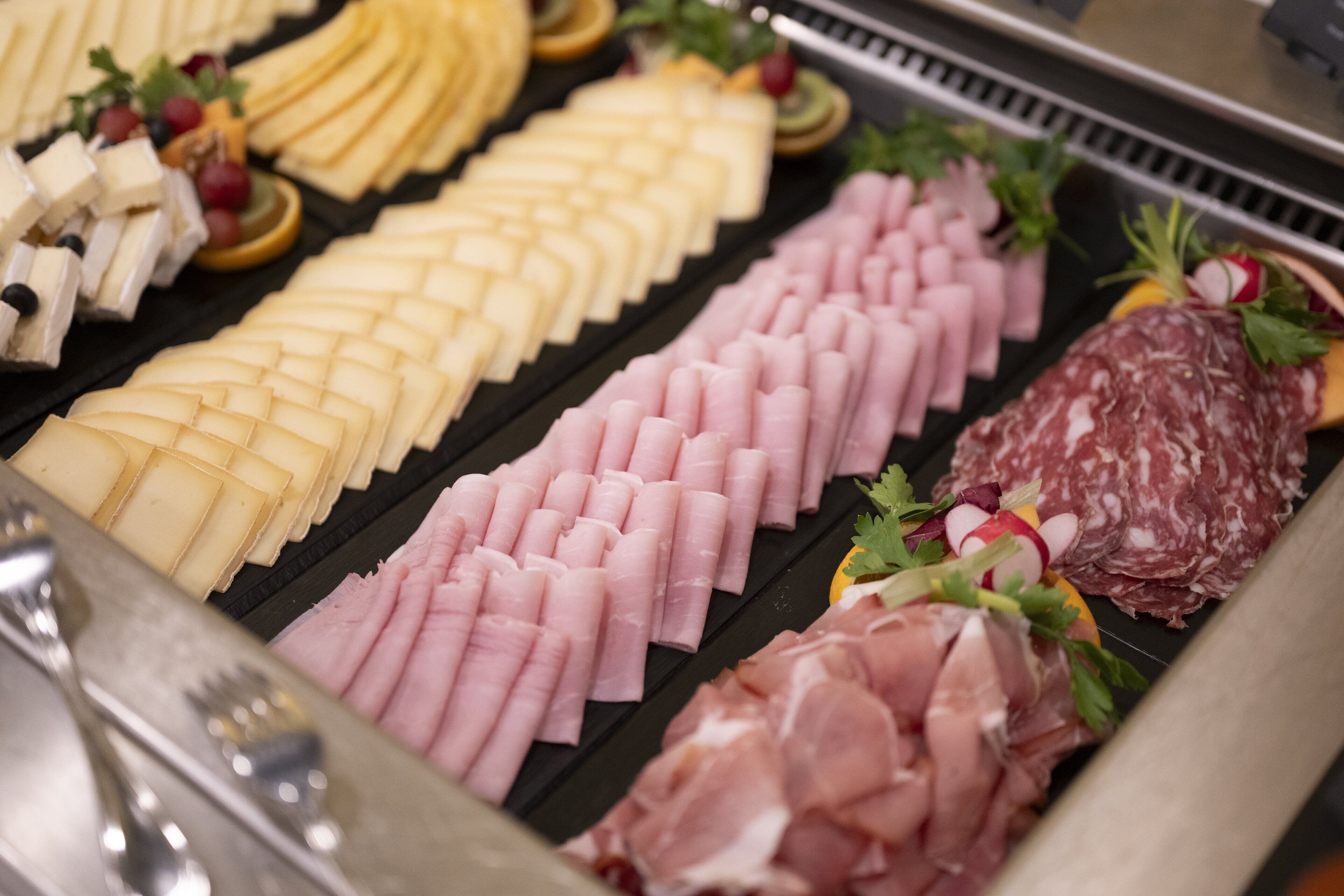 A charcuterie board with various meats and cheeses.