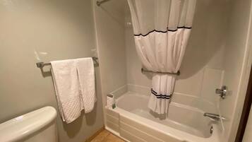 A bathroom with a toilet, a bathtub, and a shower curtain.