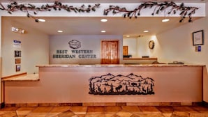 A reception desk with a sign reading "Best Western Sheridan Center" and a mountain silhouette mural. - Best Western Sheridan Center (Sheridan)