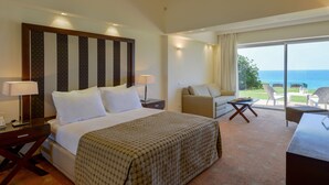 Una habitació d'hotel amb un llit gran, una taula de treball, una cadira i vistes a l'oceà.
