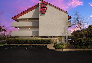 A Red Roof Inn with a multi-story structure, a parking lot, and a landscaped area with shrubs. - Red Roof Inn Wilkes-Barre Arena (Wilkes-Barre)