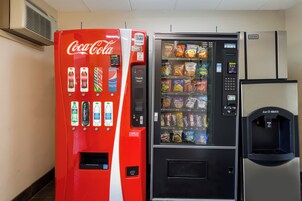 A vending machine with a Coca-Cola logo and a snack vending machine next to it.