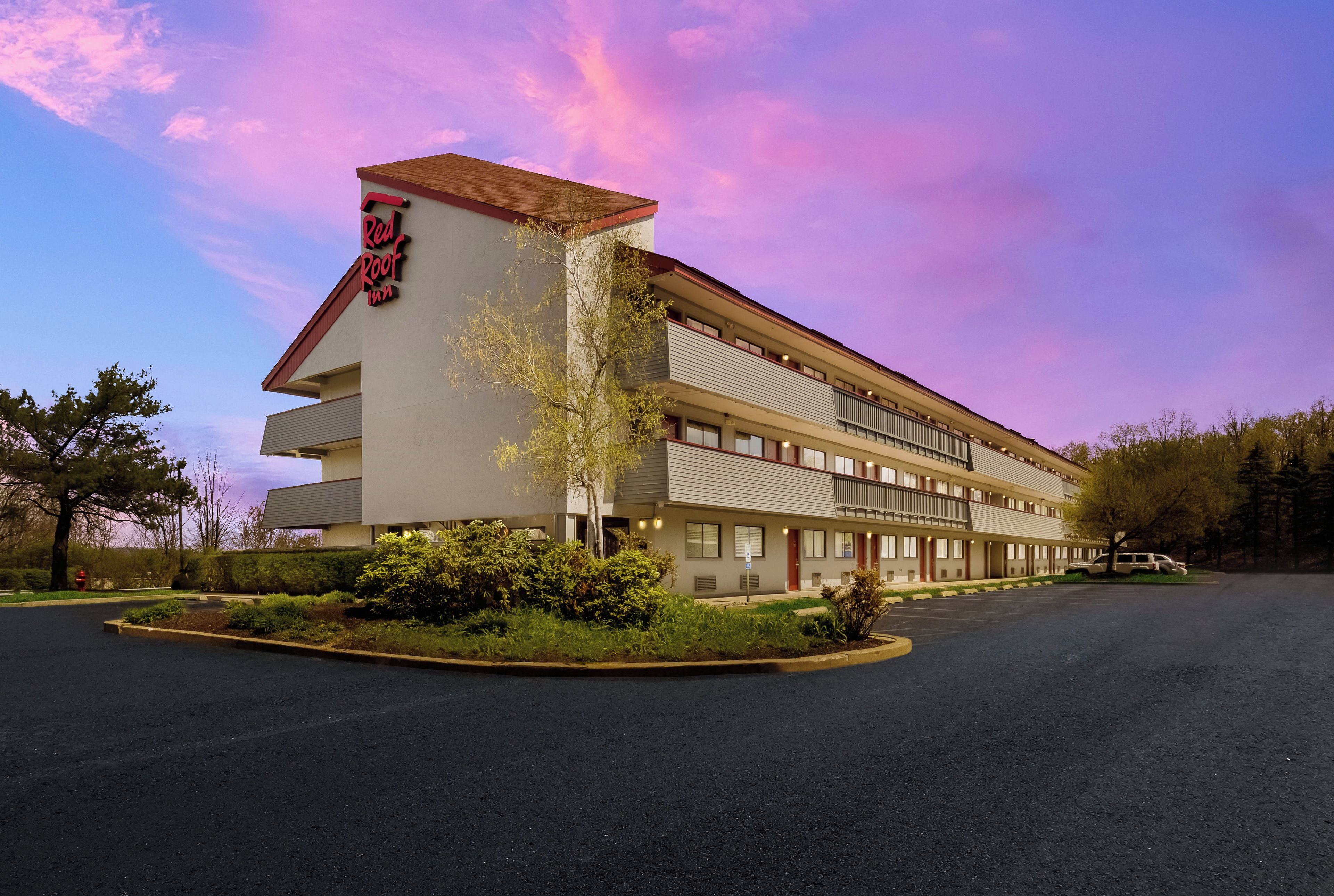 A Red Roof Inn with a modern design, featuring a flat roof and multiple balconies.