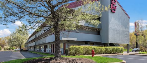 A Red Roof Inn with a modern design, a parking lot, and a well-maintained lawn.