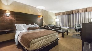 Una camera d'albergo con un letto grande, una scrivania, una sedia e una televisione.