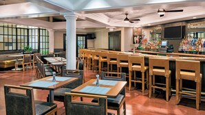 A restaurant with multiple seating areas, including tables and bar stools, and a bar counter with a variety of bottles. - Sheraton Harrisburg Hershey Hotel (Harrisburg)