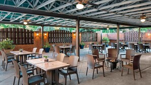 An outdoor patio area with tables and chairs, a fire pit, and potted plants. - Sheraton Harrisburg Hershey Hotel (Harrisburg)