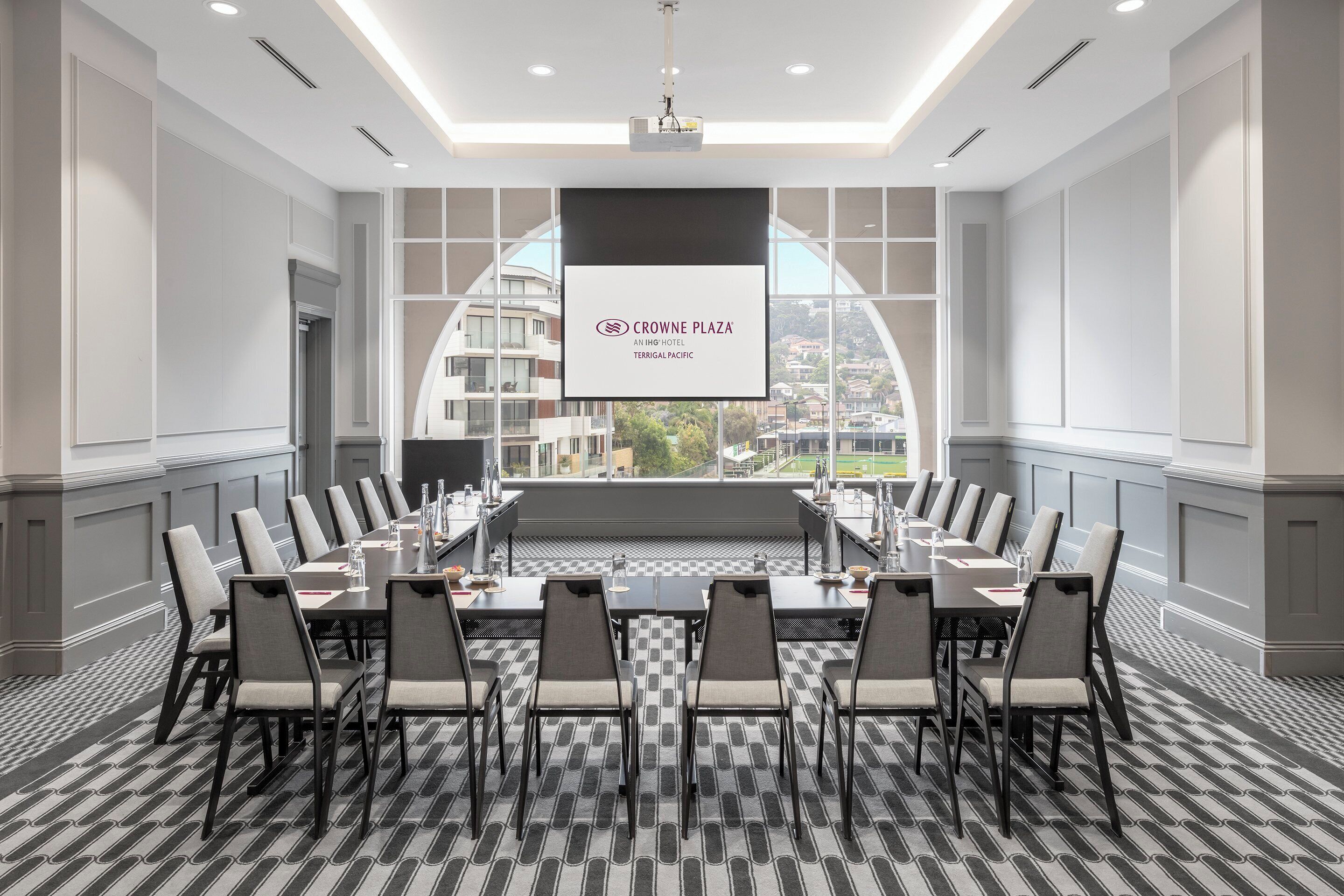 Une salle de conférence avec une longue table, des chaises et une vue sur la ville.