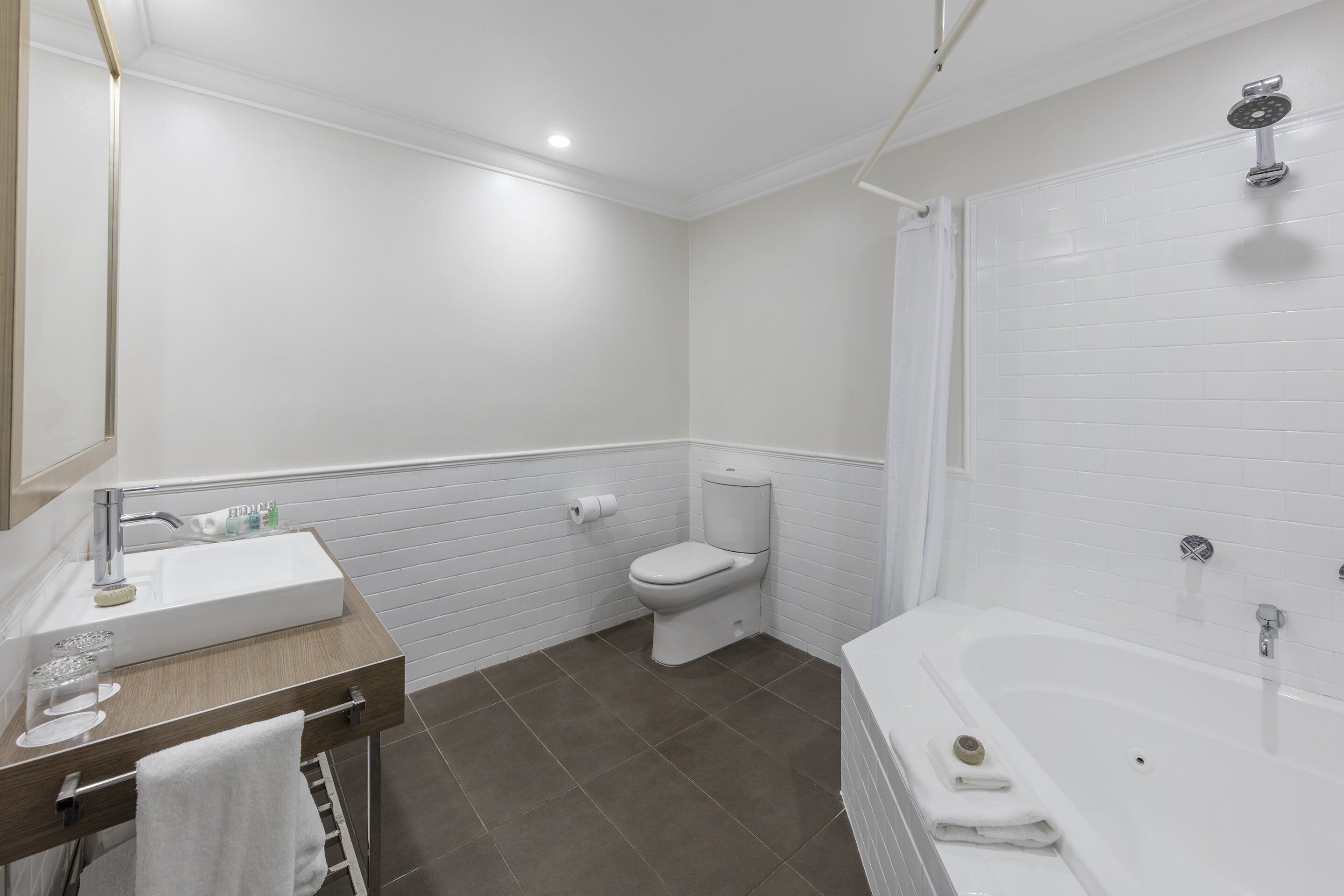 A modern bathroom with a white sink, toilet, and bathtub.