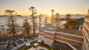 A hotel with a pool area, outdoor seating, and a view of the sea at sunset. - Crowne Plaza Terrigal Pacific by IHG (Terrigal)