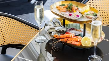 Una mesa con mariscos, una copa de champán y una botella de champán.